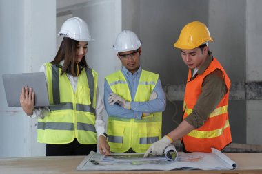 Mühendis ve mimarlardan oluşan bir ekip inşaat alanının planlarını, inşaat konseptini tasarlıyor, tasarlıyor, planlıyor ve ölçüyor..