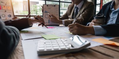 Çeşitli iş adamları şirket mali istatistiklerini tartışmak için birlikte çalışırlar, çok ırklı çalışanlar toplantıda finans belgesiyle beyin fırtınası yaparlar. Yakın çekim.