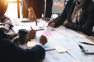 Çeşitli iş adamları şirket mali istatistiklerini tartışmak için birlikte çalışırlar, çok ırklı çalışanlar toplantıda finans belgesiyle beyin fırtınası yaparlar. Yakın çekim.