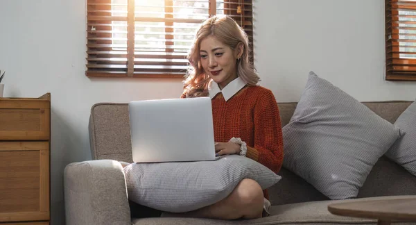 Mulher Sorrindo Usando Computador Portátil Casa Sentado Confortavelmente Sofá Sala — Fotografia de Stock
