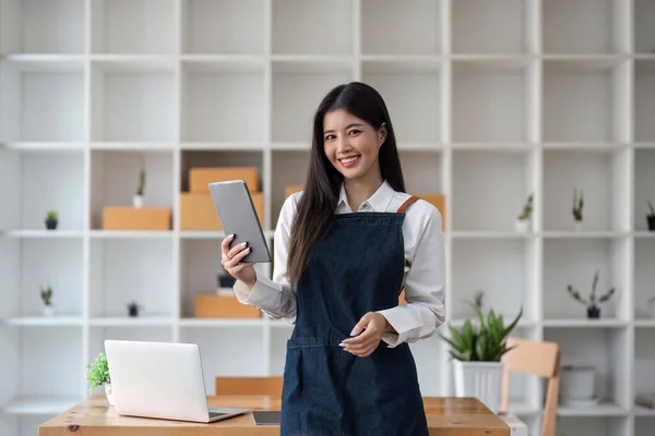 创办中小企业的亚洲自由女企业家利用平板电脑和盒子在网上接收和审查订单 准备打包销售给客户 网上羞辱商业理念 — 图库照片