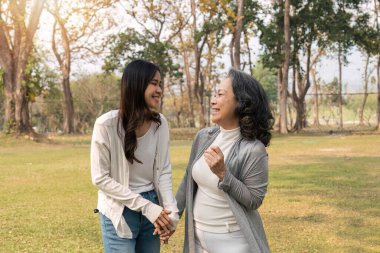 Mutlu yaşlı kadın ve torunları parkta birlikte yürüyorlar..
