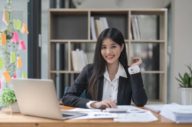 Kadın muhasebeci ofis finans ve muhasebe kavramında hesap makinesi ve bilgisayar kullanıyor.
