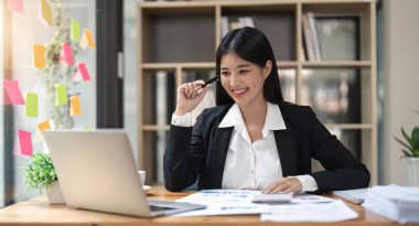 Kadın muhasebeci ofis finans ve muhasebe kavramında hesap makinesi ve bilgisayar kullanıyor.