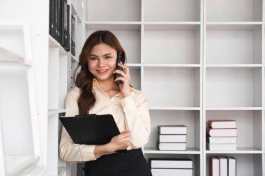 Ofisteki bir telefon görüşmesinde konuşan iş kadını. Mutlu kadın profesyonel iş arkadaşlarını cep telefonundan arıyor..