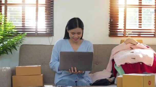 成功した女性はノートパソコンを使って自宅で製品をオンラインで販売し — ストック動画