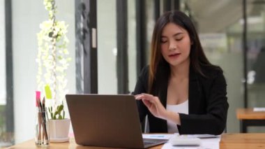 Hesap makinesi ve dizüstü bilgisayar kullanan kadın muhasebeci, cihaz ekranında istatistik grafikleri. Ödemeleri güvenli banka sistemi üzerinden yapın, şirket harcamalarını analiz edin harcamaları hesaplayın.