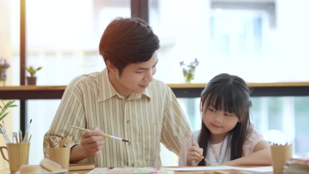 快乐的亚洲家庭在家里 爸爸在客厅教小女儿用彩笔画和在纸上画画 — 图库视频影像