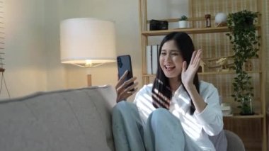 Kadın akıllı telefonda ailesiyle ya da arkadaşlarıyla görüntülü konuşma yapıyor..