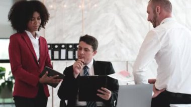 Yeni evrak projeleri hakkında fikir alışverişinde bulunan iş adamları birlikte çalışarak başarı stratejisi planlıyorlar. Çok ırklı iş arkadaşları ofis toplantılarında pazarlama konusunda fikir alışverişinde bulunuyorlar..