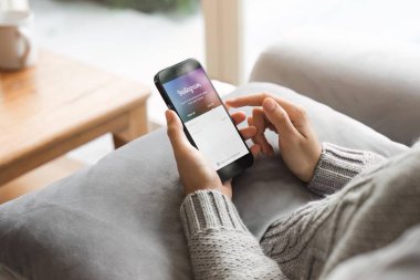 CHIANG MAI, THAILAND - 24 APR 2023: Bir kadın evdeki ekranda Instagram uygulamalı Apple iPhone 'u tutuyor. Instagram akıllı telefonlar için fotoğraf paylaşım uygulamasıdır.