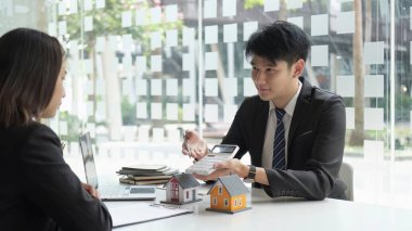 Emlakçılar müşterilerle konuşur, iyi faiz oranları sunar ve mortgage finansmanında müşterileri hesaplarlar.