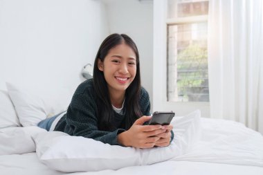 Kanepede oturmuş telefonda oynayan güzel bir kadın..