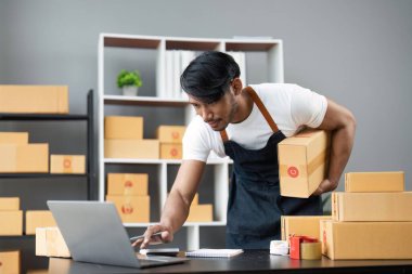 Çevrimiçi iş fikirleri. Asyalı iş adamı, elinde kolilerle müşterilere mutlu bir şekilde teslim etmeye hazırlanıyor..