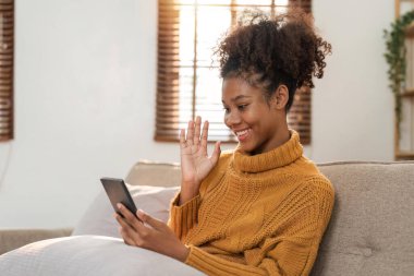 Ailesine ya da arkadaşlarına evinde telefonla eşlik eden genç Afrikalı kadınların tatil ve boş fikirleri..