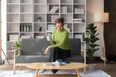 İş muhasebesi için hesap makinesi kullanan kadın kiracı, banka kredisi, kira ödemeleri, harcamalar, evrak işleri, gayrimenkul konsepti gibi masrafları karşılar..