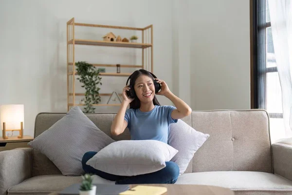 Asyalı Genç Bir Kadın Evdeki Kanepede Dinlenirken Müzik Dinliyor — Stok fotoğraf