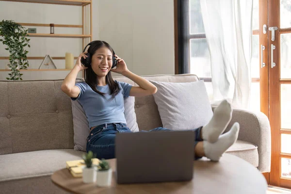 Jovem Mulher Usando Laptop Casa Ouve Música Através Fones Ouvido — Fotografia de Stock