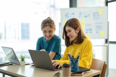 Bir grup genç Asyalı yaratıcı iş adamı beyin fırtınası sunumu, ürün tanıtımının yol haritası, planlama, ofiste yeni bir strateji başlatma projesi hakkında tartışıyorlar..