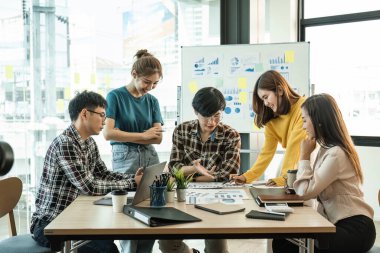Bir grup genç Asyalı yaratıcı iş adamı beyin fırtınası sunumu, ürün tanıtımının yol haritası, planlama, ofiste yeni bir strateji başlatma projesi hakkında tartışıyorlar..