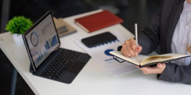 Bilgisayara bakan iş kadını çevrimiçi webinar eğitimi alıyor veya sanal toplantı video konferansı yapıyor not alıyor, ofiste pazar araştırması yapıyor...