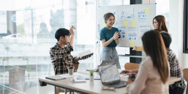 Bir grup genç Asyalı yaratıcı iş adamı beyin fırtınası sunumu, ürün tanıtımının yol haritası, planlama, ofiste yeni bir strateji başlatma projesi hakkında tartışıyorlar..