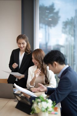 Bir grup genç Asyalı yaratıcı iş adamı beyin fırtınası sunumu, ürün tanıtımının yol haritası, planlama, ofiste yeni bir strateji başlatma projesi hakkında tartışıyorlar..