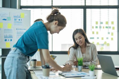 Bir grup genç Asyalı yaratıcı iş adamı beyin fırtınası sunumu, ürün tanıtımının yol haritası, planlama, ofiste yeni bir strateji başlatma projesi hakkında tartışıyorlar..