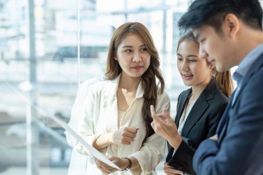 Bir grup genç Asyalı yaratıcı iş adamı beyin fırtınası sunumu, ürün tanıtımının yol haritası, planlama, ofiste yeni bir strateji başlatma projesi hakkında tartışıyorlar..
