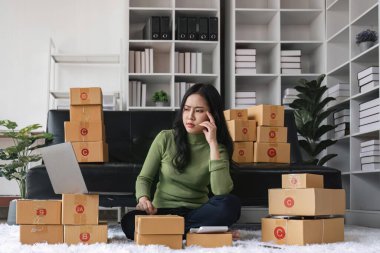 Genç girişimci kadın kargo kutusunu paketliyor teslimat paketini hazırlıyor, Çevrimiçi iş, dış ticaret ve teslimat kavramı. stres baş ağrısı.