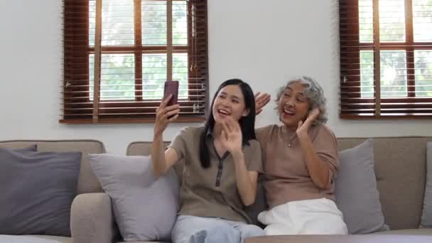 上了年纪的女人和女儿笑着 开心地 与家人进行视频聊天 — 图库视频影像