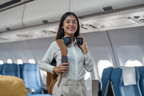 stock image Joyful tourist woman looking out the camera in airplane.