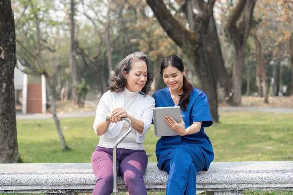 Enfermera Mostrando Informe Médico Mujer Mayor Tableta Digital Parque Hospitalario —  Fotos de Stock