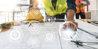 Mühendis, çalışma ve tablet verilerini analiz ediyor. Sanal simge diyagramındaki inşaat alanındaki mimari proje üzerinde çalışıyor..