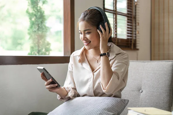 Vrouw Die Naar Muziek Luistert Hoofdtelefoon Gebruikt Bank Woonkamer Zit — Stockfoto