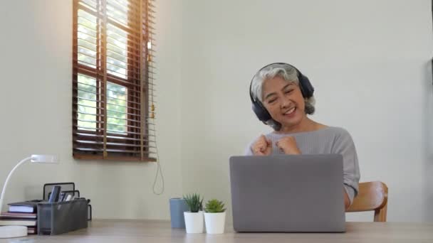 Kulaklıklı Mutlu Güzel Yaşlı Bir Kadın Evdeki Masada Oturan Müzik — Stok video