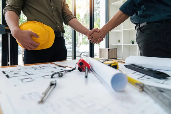 stock image Professional Asian male engineer shaking hands with male architect after the meeting is over at office.