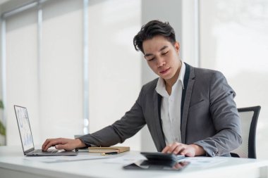 İş adamı, ofis ve çalışma vergisi, muhasebe, istatistik ve analitik araştırma konseptini hesaplamak için hesap makinesi kullanıyor..