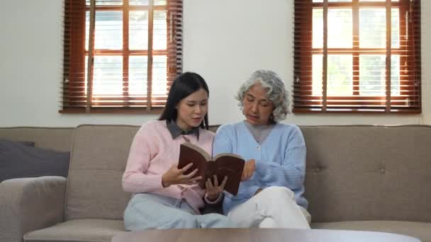 Alte Mutter Und Tochter Glücklich Buch Lesen Sitzt Auf Dem — Stockvideo