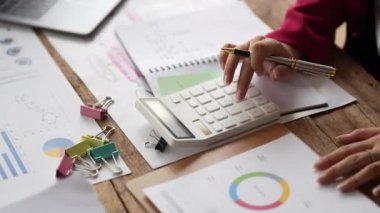 Çek, vergi, banka hesap bakiyesi ve evdeki oturma odasındaki harcamaları hesaplamak için hesap makinesi kullanan kadının elini kapat...