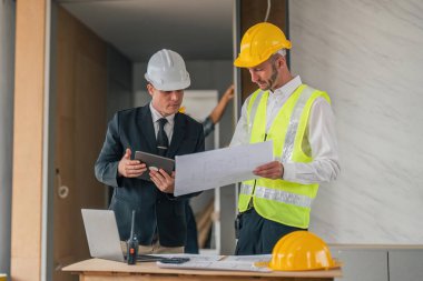 Professional construction engineers team using blueprint of project plan brainstorming and working together at construction building, Architecture and building construction concept.