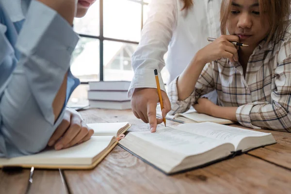 stock image Distracted from preparing college project happy young laughing diverse classmates having fun, telling jokes, enjoying carefree pause time together, sitting at table in library.