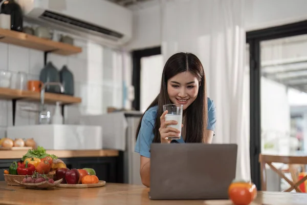 Mulher Bonita Com Laptop Bebendo Leite Cozinha — Fotografia de Stock