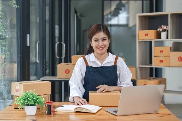 快乐的年轻亚洲女人创办了小商业电脑笔记本电脑 坐在椅子上 在线营销包装盒送货理念 — 图库照片