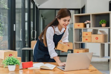 Business From Home Asian woman preparing package delivery box Shipping for shopping online. young start up small business owner at home online order.