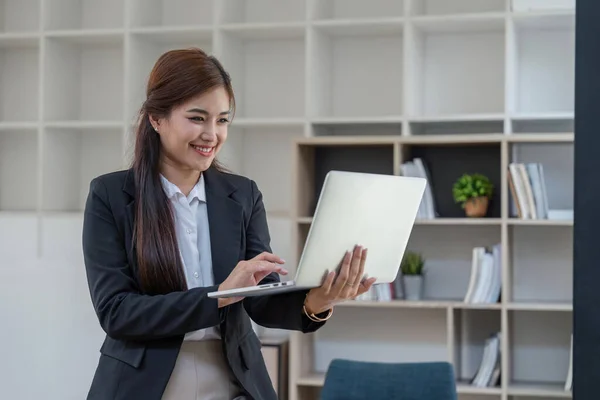 現代の企業のオフィスで働く技術デバイスを使用してラップトップを保持する若いスマートビジネス女性 女性の会社の労働者またはマネージャー — ストック写真