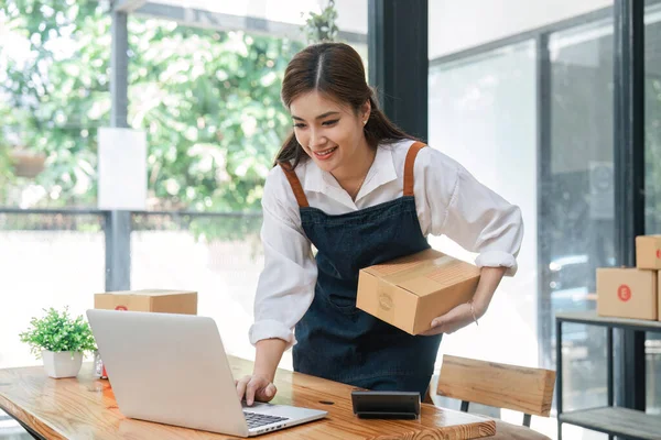 来自亚洲家庭的女性为网上购物准备包裹递送箱 年轻人在家里创办小企业主在线订购 — 图库照片