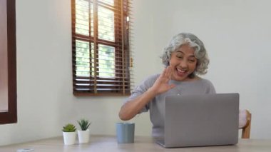 Neşeli yaşlı bayan video bağlantısı yoluyla arkadaşları ya da ailesiyle irtibat halinde..