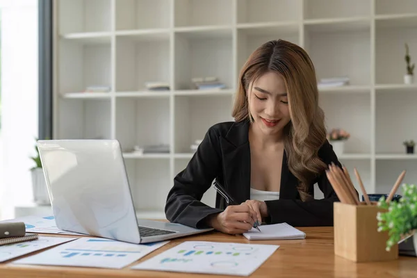 ビジネスの女性はノートパソコンで働き ノートパッドで書く手 ビジネス金融の概念 — ストック写真