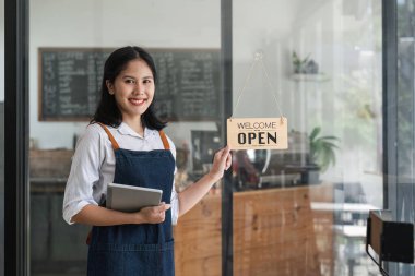 Başlangıçta başarılı olan küçük işletme sahibi, kafeterya restoranında elinde tabletle güzel bir kız standı açmıştı. Asyalı kadın kahveci kafenin sahibinin portresi. KOBİ girişimci iş konsepti.